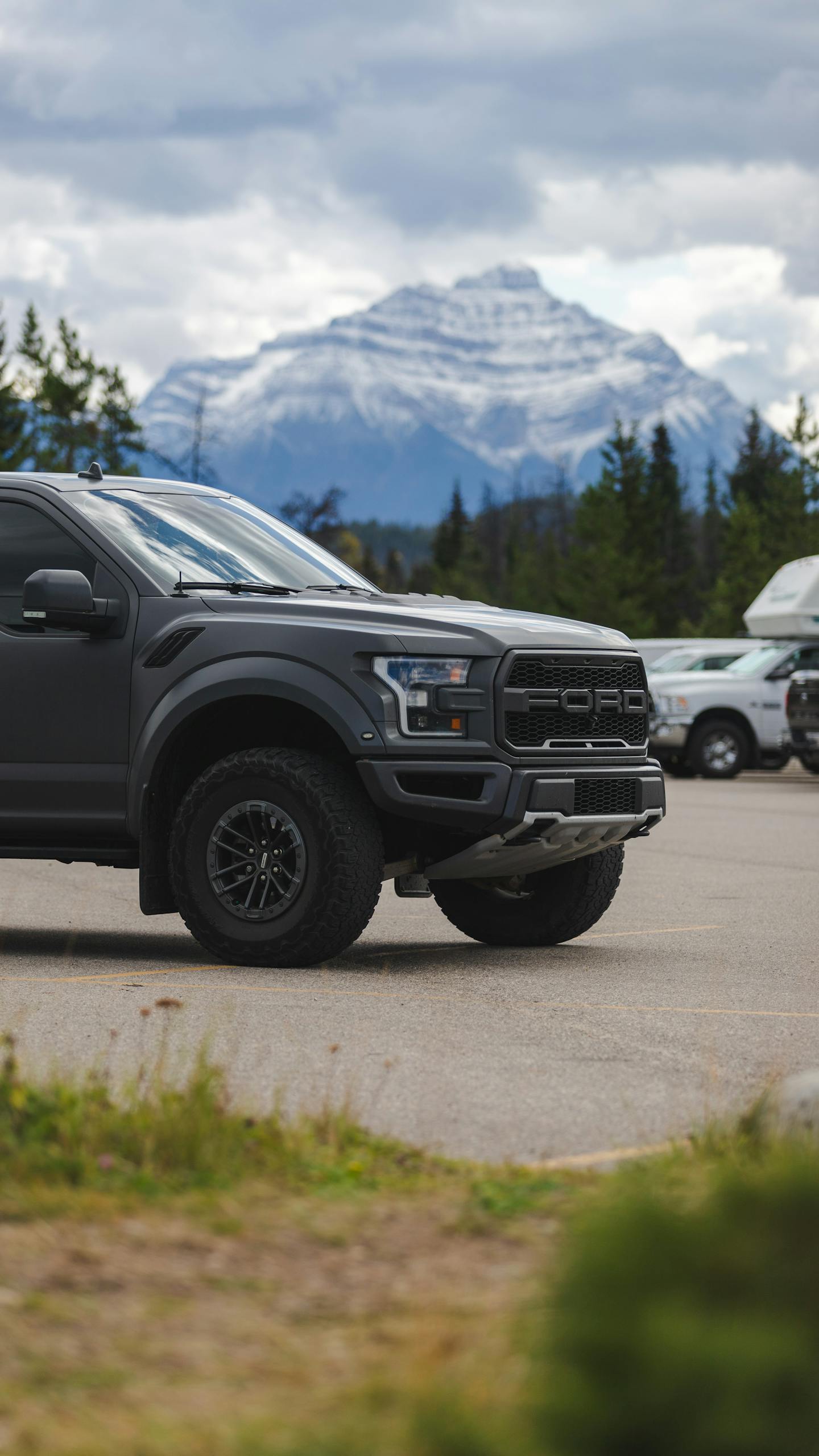 A rugged black truck parked with a majestic mountain backdrop, capturing adventure and style.